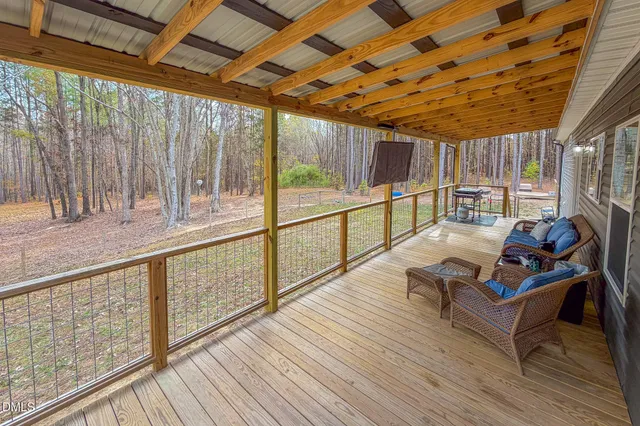 a view of a balcony with chairs and wooden floor