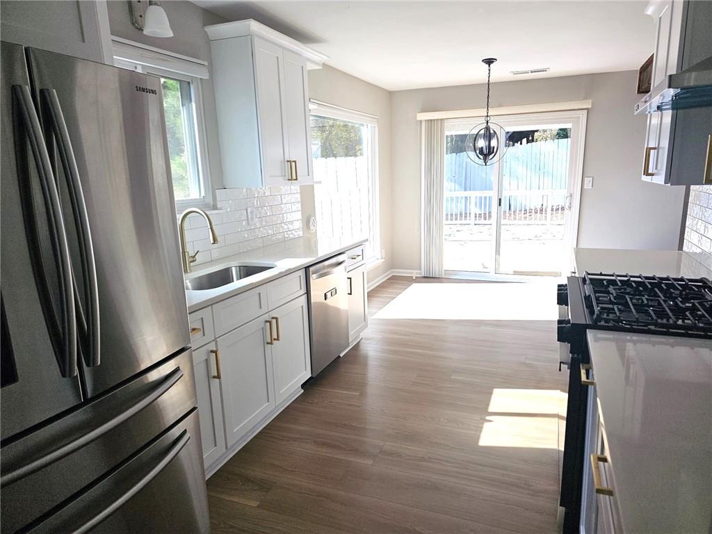 10085 Old Woodland Entry Johns Creek, GA 30022 - Photo 11 of 34 a kitchen with granite countertop a refrigerator a sink a stove and cabinets