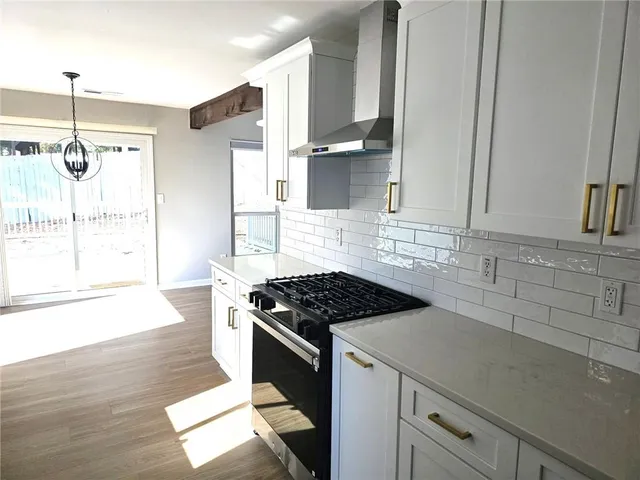 a kitchen with granite countertop a stove a sink and a refrigerator