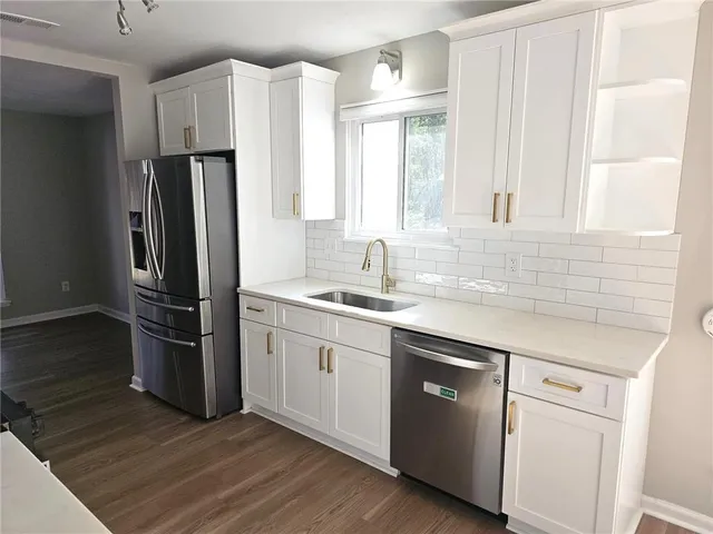a kitchen with stainless steel appliances a refrigerator sink and cabinets