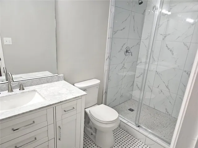 a bathroom with a granite countertop sink toilet and shower