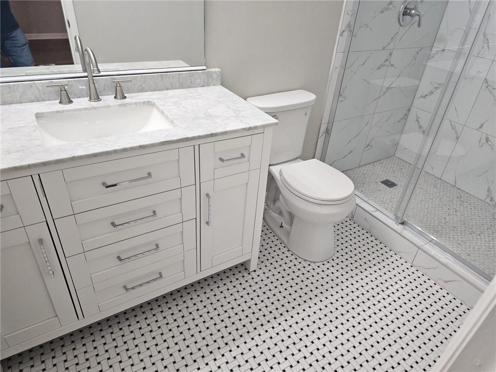 10085 Old Woodland Entry Johns Creek, GA 30022 - Photo 20 of 34 a bathroom with a sink a toilet and a mirror