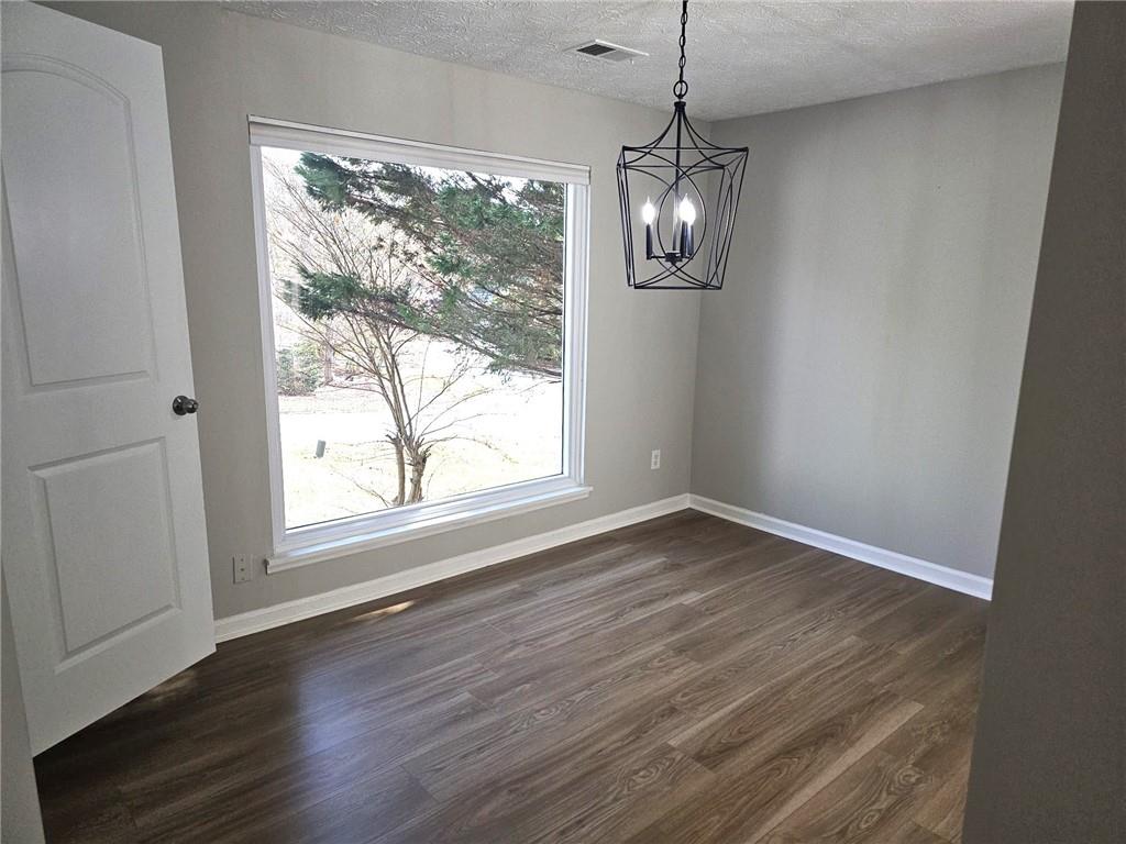 10085 Old Woodland Entry Johns Creek, GA 30022 - Photo 6 of 34 a view of an empty room with wooden floor and a window