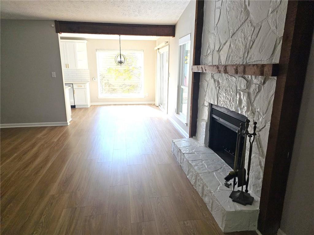 10085 Old Woodland Entry Johns Creek, GA 30022 - Photo 9 of 34 an empty room with wooden floor fireplace and windows