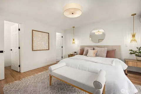 a bedroom with a bed and painting on the wall