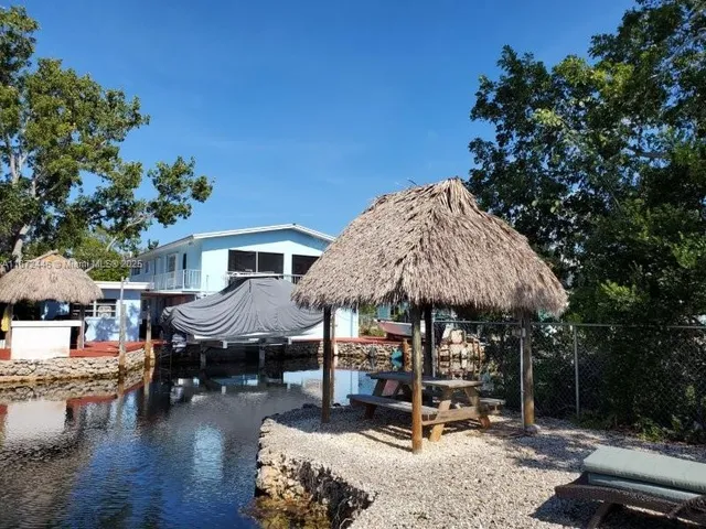 a patio with a table and chairs under an umbrella