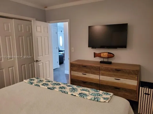 a bedroom with a bed and a flat screen tv