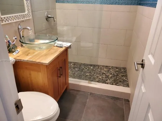 a bathroom with a granite countertop sink toilet and shower