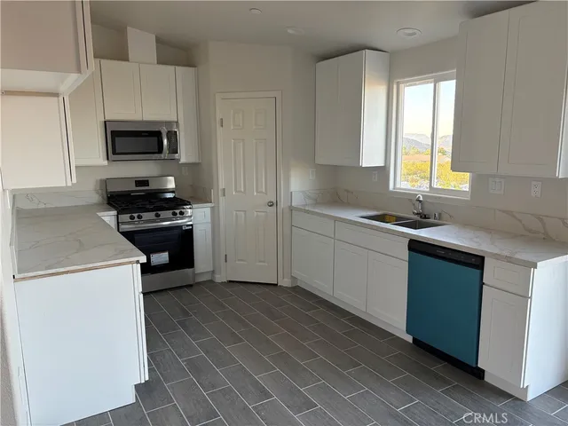 a kitchen with stainless steel appliances a stove sink microwave and cabinets