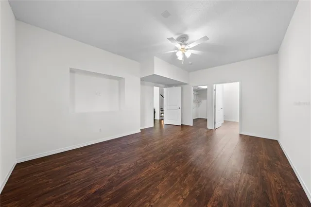 a view of a hallway with wooden floor and a living room