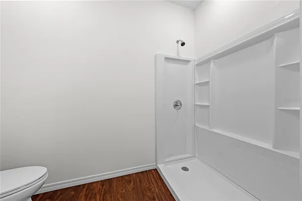 a view of empty room with wooden floor