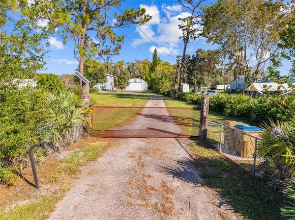 an empty room with wooden floor ceiling fan and windows