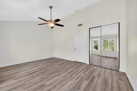a view of a room with wooden floor and furniture