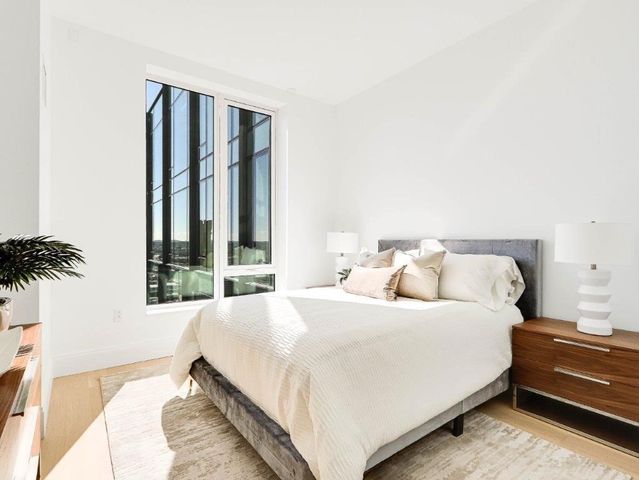 a bedroom with a bed and a potted plant
