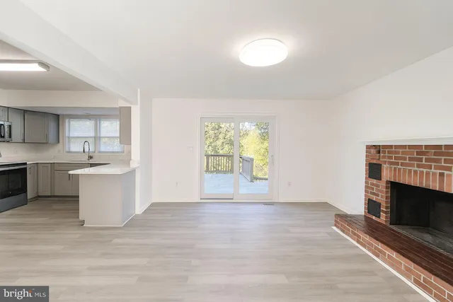 a view of a kitchen with a sink a fireplace and a window