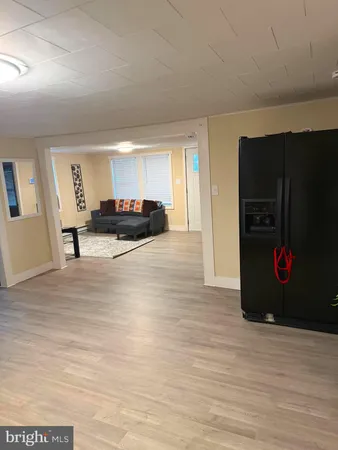 a view of a livingroom with furniture cabinets and a floor to ceiling window