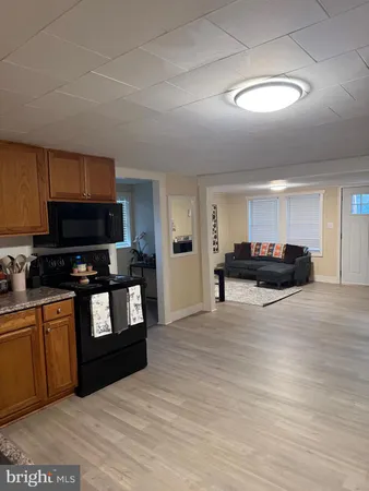 a living room with stainless steel appliances kitchen island granite countertop a stove a sink and a microwave