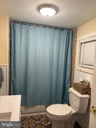 a white toilet sitting next to a shower curtain