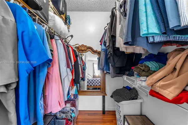 a view of walk in closet with clothes and shoes