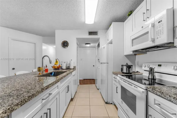 a kitchen with stainless steel appliances granite countertop a sink stove and cabinets