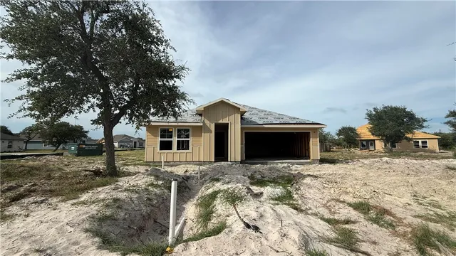 a view of house with yard and tree in the background