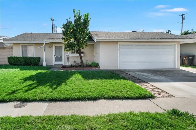 a front view of a house with a garden and plants