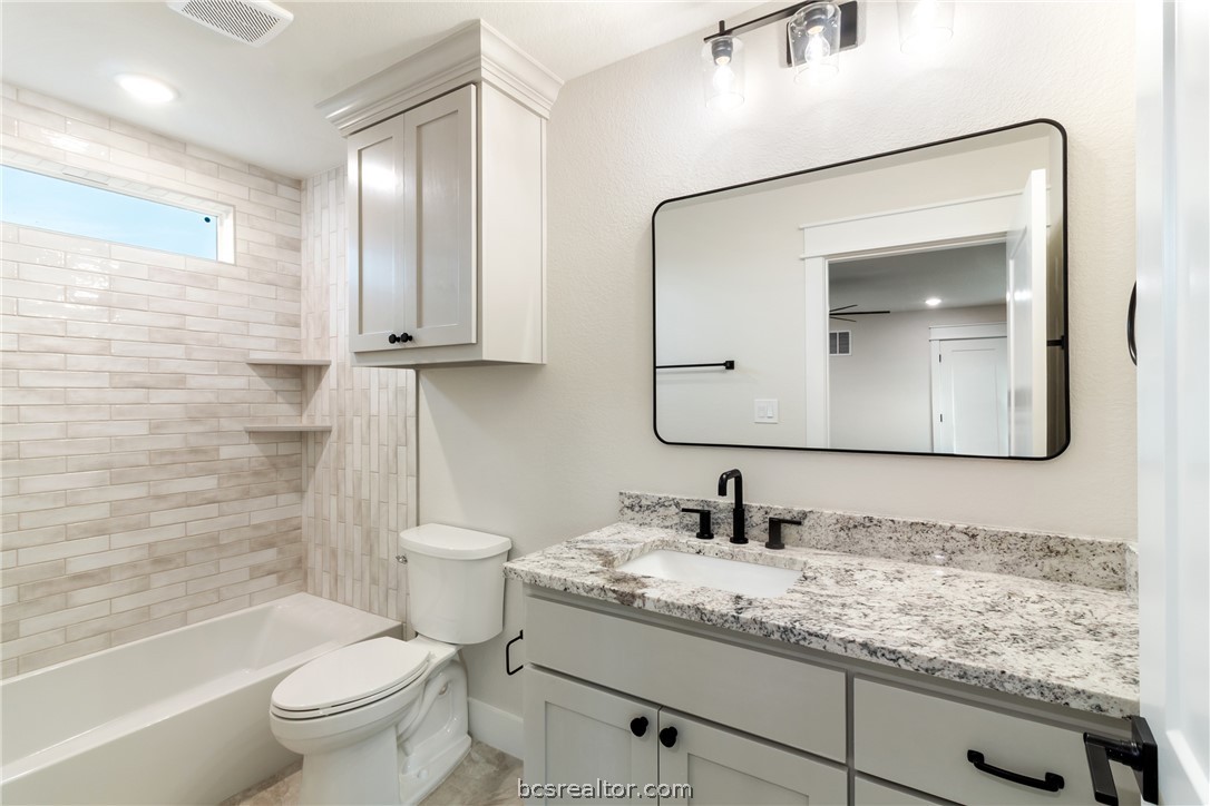 7822 Mathis Crk Drive Bryan, TX 77808 - Photo 32 of 43 a bathroom with a granite countertop sink toilet and mirror