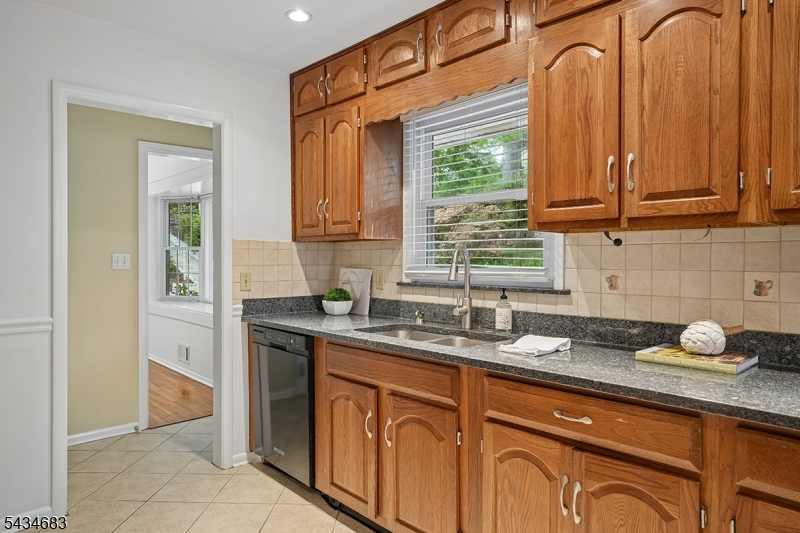 106 Division Avenue Summit, NJ 07901 - Photo 11 of 38 a kitchen with stainless steel appliances granite countertop a sink a stove cabinets and a window