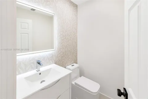 a white toilet sitting next to a bathroom sink