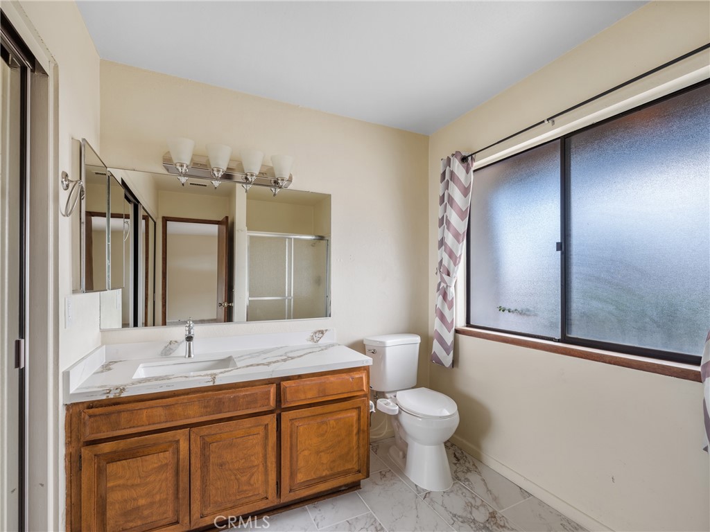 19236 Hupa Road Apple Valley, CA 92307 - Photo 22 of 44 a bathroom with a toilet sink and mirror