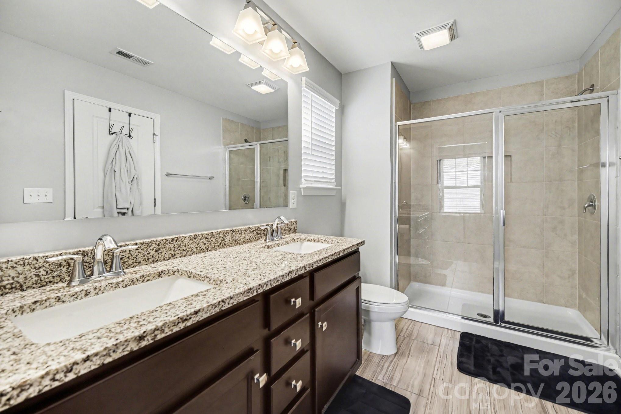 6423 Kinder Lane Lancaster, SC 29720 - Photo 28 of 48 a bathroom with a granite countertop sink a toilet a mirror and shower