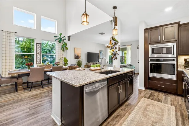 a dining room with furniture potted plants and wooden floor