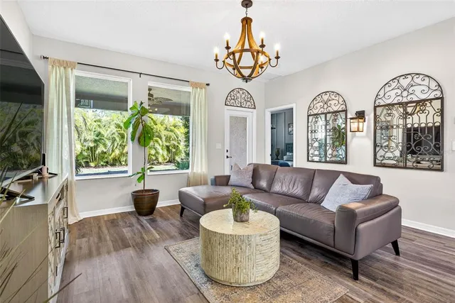 a living room with furniture a flat screen tv and a floor to ceiling window