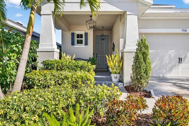 a kitchen with stainless steel appliances granite countertop a refrigerator a stove a kitchen island with chairs and wooden floor