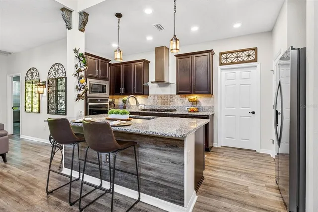 a kitchen with granite countertop a sink and a wooden floor