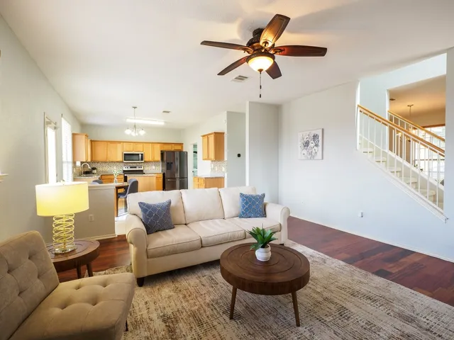 a living room with furniture and a wooden floor