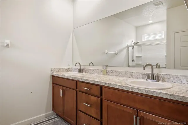 a bathroom with a granite countertop toilet and a shower