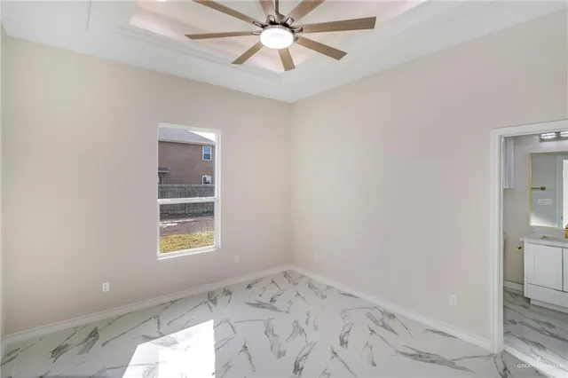 an empty room with a window and ceiling fan
