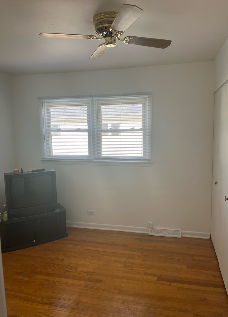 8812 Dee Road Des Plaines, IL 60016 - Photo 8 of 13 a view of an empty room with wooden floor and a window