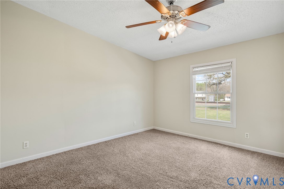 9711 Robin Road Disputanta, VA 23842 - Photo 21 of 29 an empty room with windows and fan