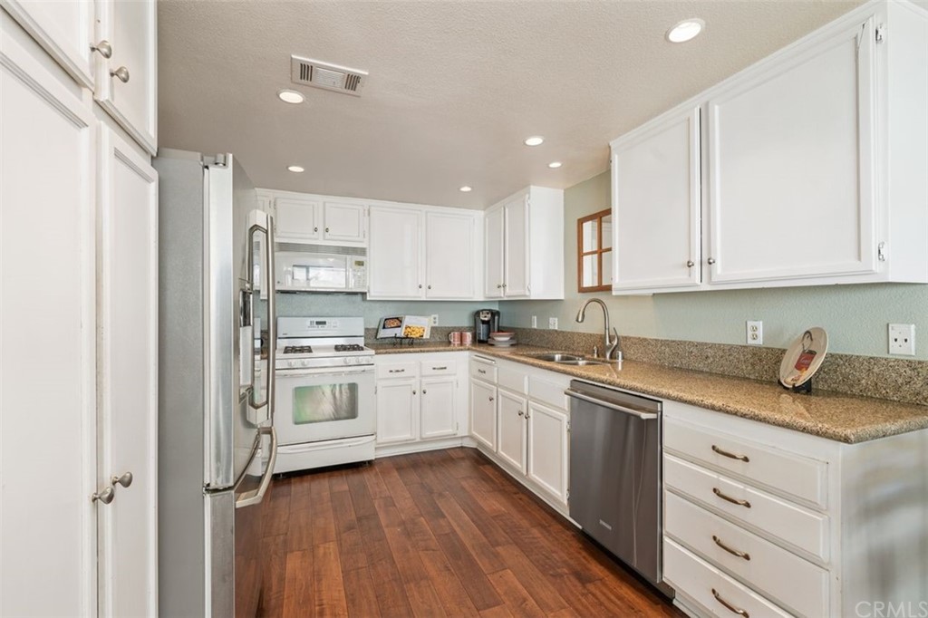 28825 Woodspring Circle Lake Forest, CA 92679 - Photo 11 of 50 a kitchen with granite countertop white cabinets and white appliances