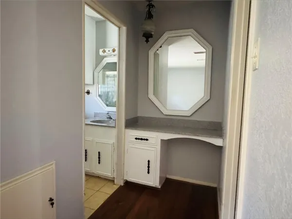 a view of a hallway with entryway wooden floor and cabinet