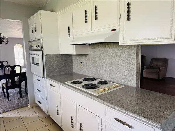 a kitchen with granite countertop white cabinets and white appliances