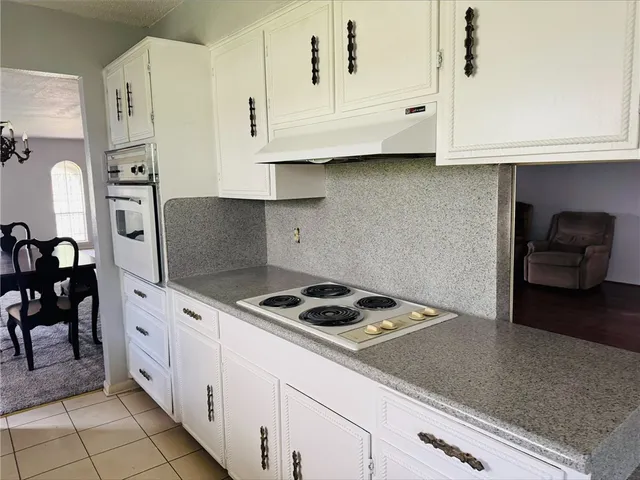 a kitchen with granite countertop white cabinets and white appliances