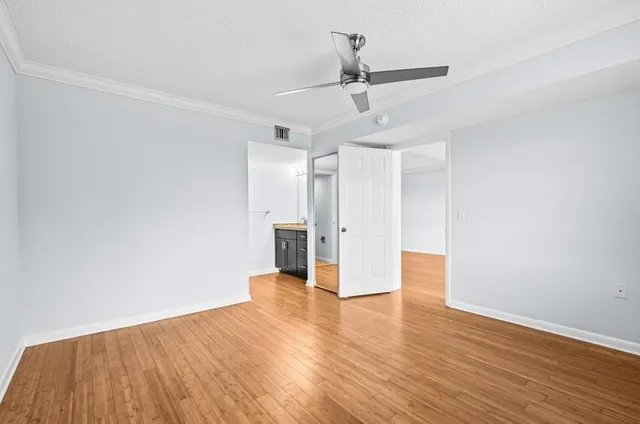 a view of a livingroom with wooden floor and a ceiling fan
