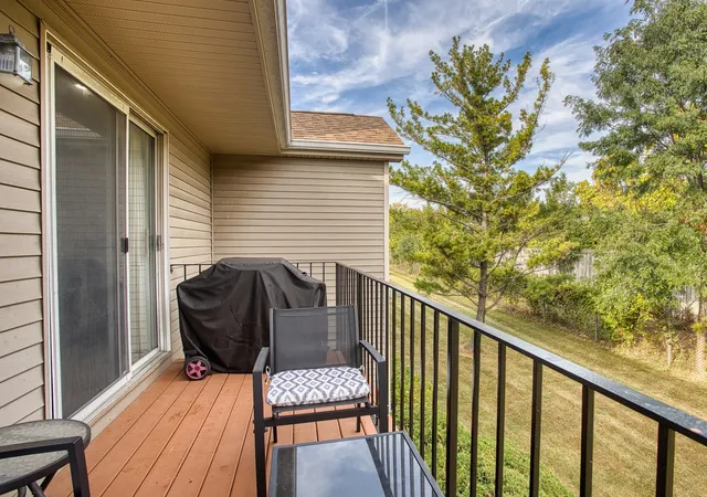 a balcony with wooden floor table and chairs