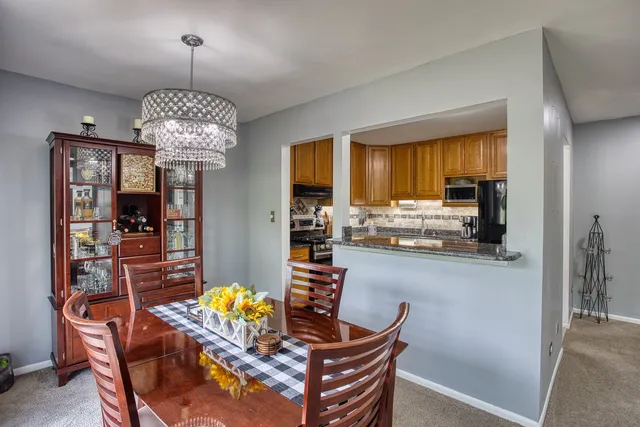 a dining room with furniture a chandelier and wooden floor
