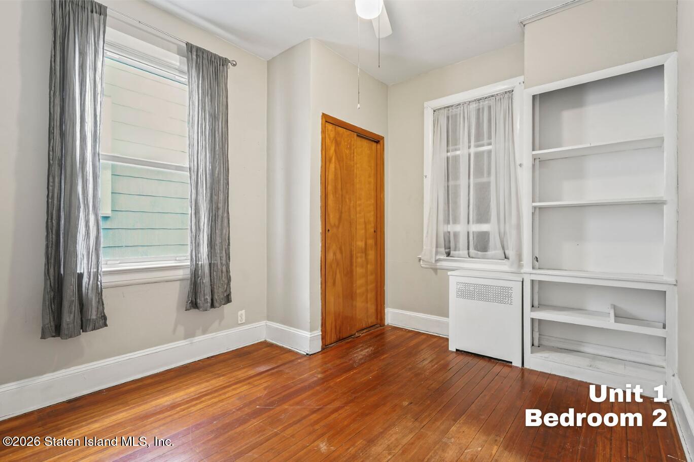 116 Silver Lake Road Staten Island, NY 10301 - Photo 12 of 36 a view of an empty room with wooden floor and a window