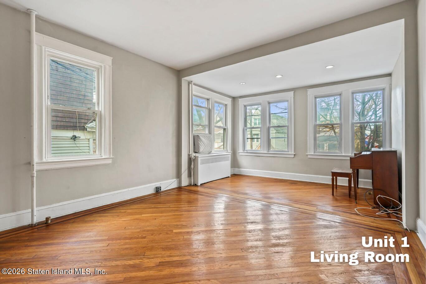 116 Silver Lake Road Staten Island, NY 10301 - Photo 2 of 36 a view of an empty room with window and wooden floor