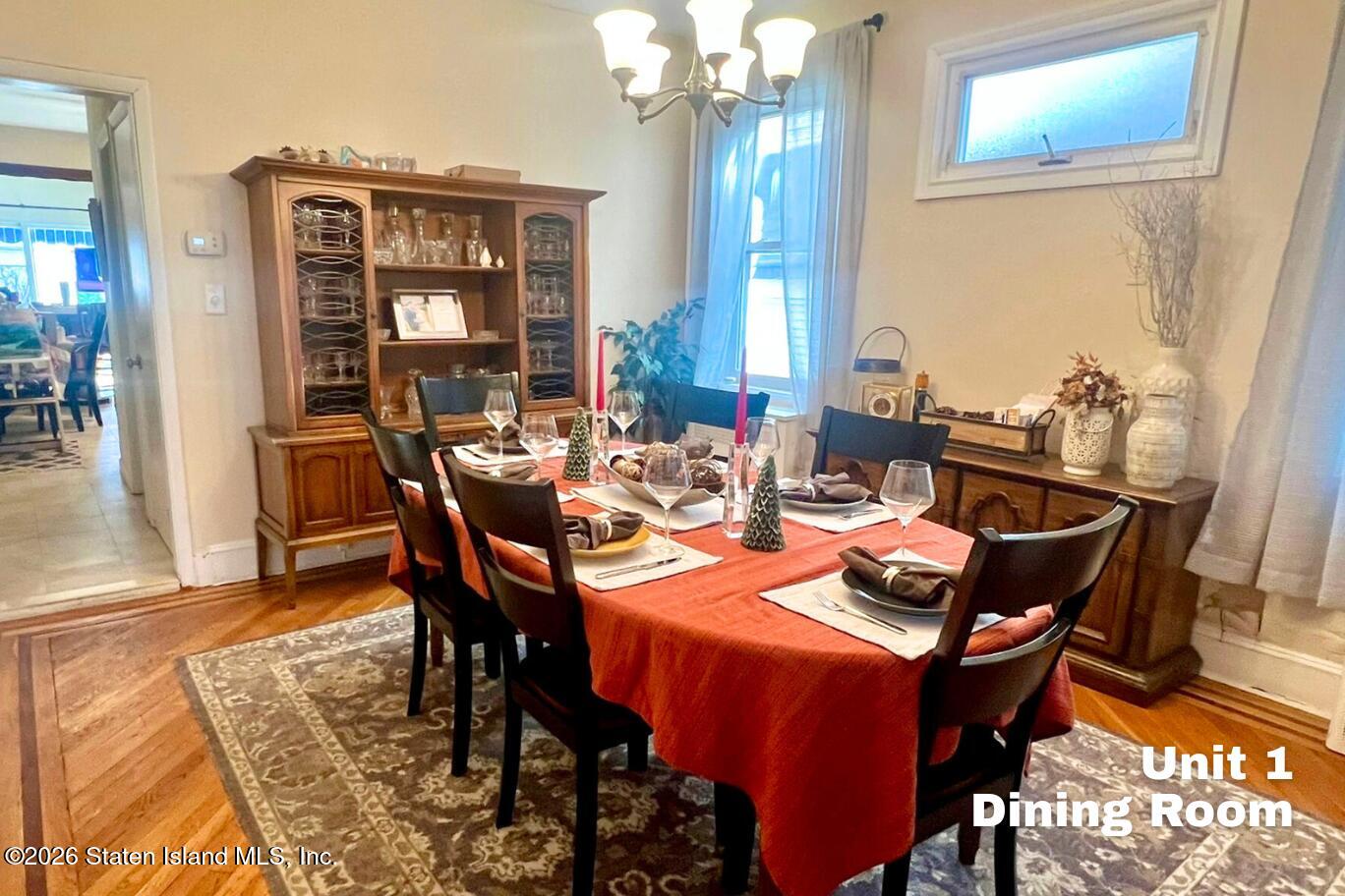 116 Silver Lake Road Staten Island, NY 10301 - Photo 8 of 36 a dining room with furniture a chandelier and wooden floor